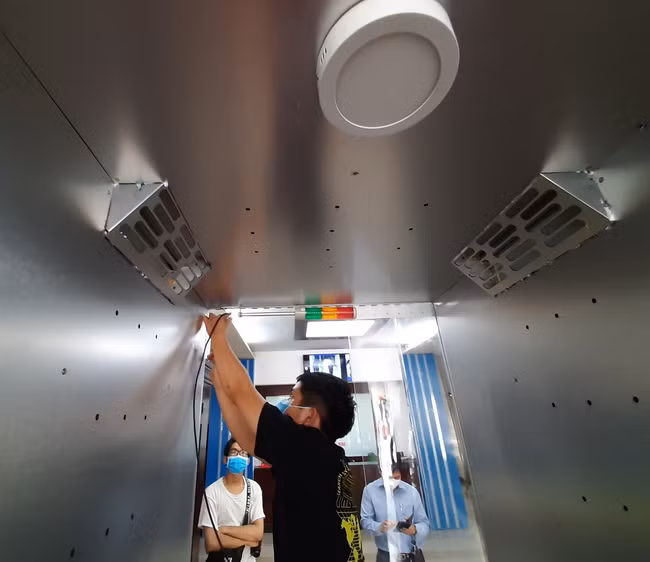 Thiết kế gồm cảm biến phát hiện người và tự động phun; có đèn tín hiệu,