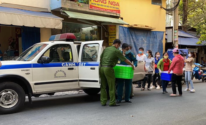 Các lực lượng chức năng cùng hỗ trợ vận chuyển đồ ăn cho bà con ở chung cư Hòa Bình.