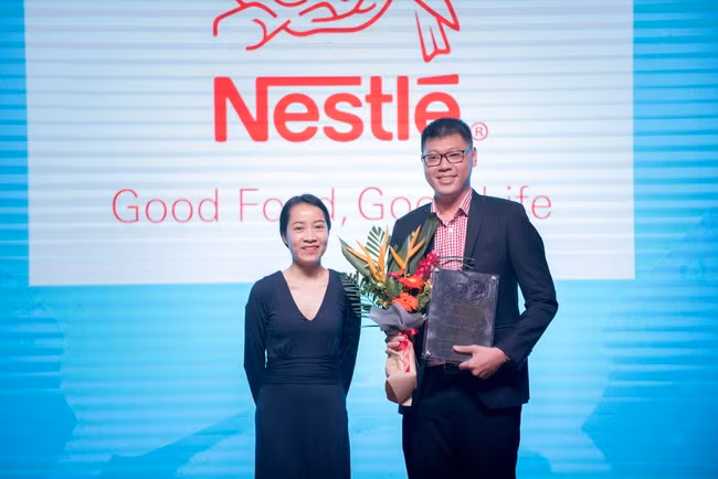 Bà Phạm Thị Diệu Anh - Giám đốc Điều hành AIM Academy, Đại diện BTC cuộc thi tặng hoa và kỷ niệm chương cho đại diện đơn vị tài trợ.