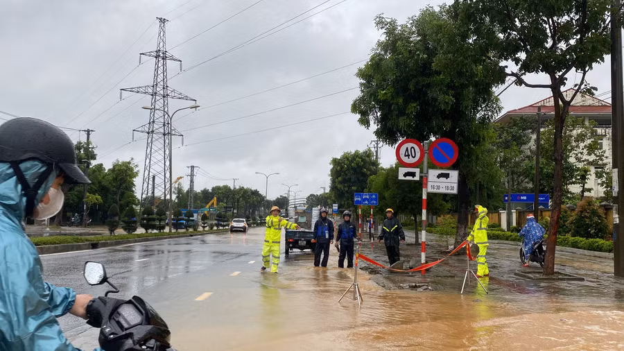 Đường Trường Sơn đoạn trước Trường Quân sự Quân khu 5 bị ngập nước, Công an phân luồng giao thông. (Ảnh: Hoàng Vinh)