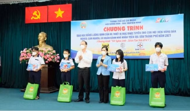 Phó Bí thư Thành ủy TP.HCM Nguyễn Hồ Hải và Chủ tịch Hội Nông dân TP Hồ Chí Minh Nguyễn Thanh Xuân trao học bổng và thiết bị học trực tuyến cho học sinh.