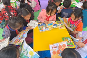 Học sinh trường PTDTBT Tiểu học & THCS Mồ Dề đọc sách, truyện trong khuôn viên trường học.