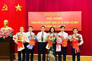 Ông Luyện Hữu Chung - Giám đốc Sở GD&ĐT trao quyết định bổ nhiệm và tặng hoa chúc mừng các cán bộ được bổ nhiệm trưởng phòng sau sắp xếp.