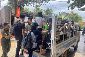 Các em học sinh tại xã Yên Thế, huyện Lục Yên đến điểm thi làm thủ tục bằng xe của công an xã. (Ảnh: CAYB)