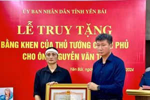 Ông Trần Huy Tuấn, Chủ tịch UBND tỉnh Yên Bái trao Bằng khen của Thủ tướng cho đại diện gia đình ông Nguyễn Văn Thi.