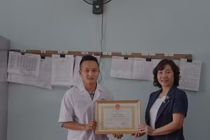 Bà Lương Thị Xuyến, Phó chủ tịch UBND huyện Mù Cang Chải, tỉnh Yên Bái tặng giấy khen của UBND huyện cho bác sĩ Giàng A Vinh.