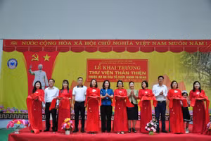 Các đại biểu cùng cán bộ giáo viên học sinh nhà trường cắt băng khai trương thư viện.