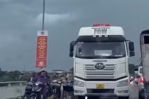 Ô tô che chắn cho các xe máy qua cầu trong mưa dông, gió lớn tại Tuyên Quang.