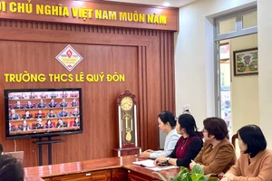 Các giáo viên Trường THCS Lê Quý Đôn theo dõi trực tiếp Đại hội XIV của Đảng qua màn hình ti vi.