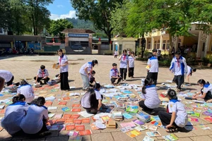 Học sinh Trường THCS Lý Tự Trọng cặm cụi phơi những cuốn sách còn phục hồi được.