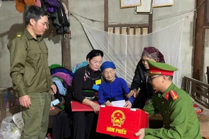 Lực lượng Công an Tuyên Quang hỗ trợ những cử tri già yếu thực hiện quyền bầu cử. (Ảnh: CATQ)