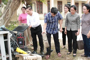 Thứ trưởng Lê Tấn Dũng kiểm tra hệ thống máy tính của Trường Tiểu học An Định bị hư hỏng hoàn toàn sau lũ. (Ảnh: Thành Tâm)