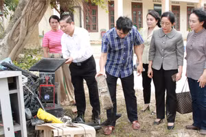 Thứ trưởng Lê Tấn Dũng kiểm tra hệ thống máy tính của Trường Tiểu học An Định bị hư hỏng hoàn toàn sau lũ. (Ảnh: Thành Tâm)