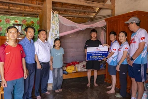 Lãnh đạo Công ty Thủy điện Buôn Kuốp trao hỗ trợ cho em Ngọc Xuân Bình. (Ảnh: TT)