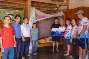 Lãnh đạo Công ty Thủy điện Buôn Kuốp trao hỗ trợ cho em Ngọc Xuân Bình. (Ảnh: TT)