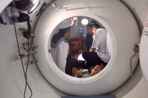 Các y, bác sĩ Bệnh xá đảo Song Tử Tây điều trị tăng áp cho bệnh nhân. (Ảnh: CTV)