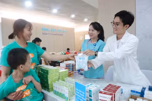 Gia đình 1 em nhỏ nhận thuốc miễn phí từ Chương trình. (Ảnh: TT)