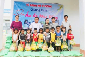 Thầy Vũ Văn Tùng (áo trắng) trao tặng quà cho học trò nghèo. (Ảnh: VT)