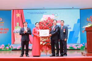 Giám đốc Sở GD&ĐT Lê Thị Thanh Xuân tặng hoa chúc mừng Trường THPT Quang Trung 40 năm hình thành và phát triển. (Ảnh: TT)