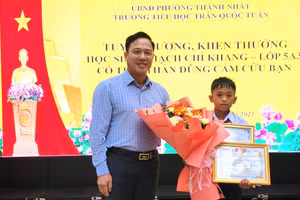 Ông Lưu Tiến Quang - Phó Giám đốc Sở GD&ĐT Đắk Lắk trao Thư, Giấy khen của Giám đốc Sở cho em Thạch Chí Khang. (Ảnh: TT)