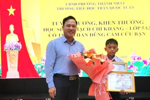 Ông Lưu Tiến Quang - Phó Giám đốc Sở GD&ĐT Đắk Lắk trao Thư, Giấy khen của Giám đốc Sở cho em Thạch Chí Khang. (Ảnh: TT)