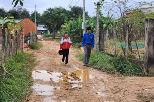 Anh Hoàng Vĩnh Hải – Bí thư Chi đoàn buôn Ea Rớt (áo xanh) đến từng nhà tuyên truyền bà con đi học chữ. (Ảnh: TT)