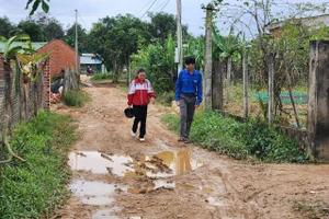 Anh Hoàng Vĩnh Hải – Bí thư Chi đoàn buôn Ea Rớt (áo xanh) đến từng nhà tuyên truyền bà con đi học chữ. (Ảnh: TT)