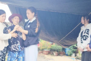 Bà Nguyễn Thị Bàng (thứ 2 từ trái qua) đã 5 ngày liền ra bờ sông khóc thương 2 đứa con mất tích do lũ cuốn. (Ảnh: Thành Tâm)