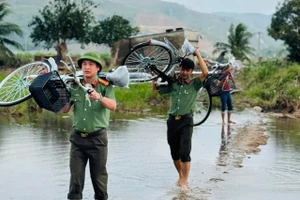 Cán bộ, chiến sĩ Công an Đắk Lắk vượt suối mang niềm vui đến thầy và trò Trường Tiểu học Phú Mỡ. (Ảnh: TT)