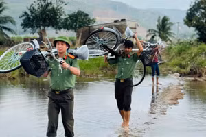 Cán bộ, chiến sĩ Công an Đắk Lắk vượt suối mang niềm vui đến thầy và trò Trường Tiểu học Phú Mỡ. (Ảnh: TT)