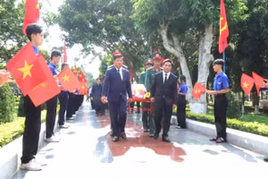 Ông Nguyễn Doãn Anh và ông Lương Nguyễn Minh Triết thực hiện nghi thức di chuyển hài cốt liệt sĩ vào vị trí an táng. (Ảnh: TT)
