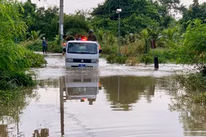 Lực lượng Công an xã Hàm Thạnh dùng xe chuyên dụng đưa học sinh, người dân qua điểm ngập lụt. (Ảnh: QT)