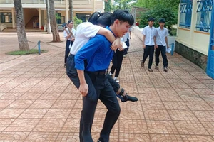 Thí sinh đến điểm thi bằng nạng được thanh niên tình nguyện cõng đến phòng thi. (Ảnh: TT)