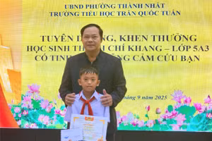 Ông Trần Xuân Kỳ - Hiệu trưởng nhà trường khen thưởng cho em Thạch Chí Khang. (Ảnh: TT)