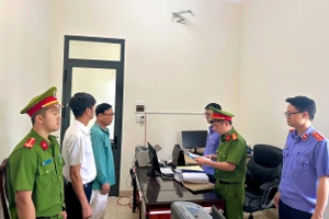 Cơ quan chức năng tống đạt các quyết định tố tụng đối với 2 bị can. (Ảnh: DQ)