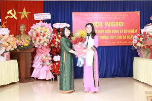 Phó Giám đốc Võ Thị Minh Duyên trao quyết định cho TS Lê Thị Thảo - Hiệu trưởng Trường THPT Cao Bá Quát. (Ảnh: TT)