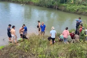 Người dân và cơ quan chức năng trục vớt 3 em nhỏ bị đuối nước.