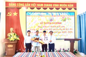 Ban Giám hiệu nhà trường chúc mừng, động viên em Nguyễn Thọ Hoàng Anh, học sinh giỏi môn Địa lí. (Ảnh: ĐTN)