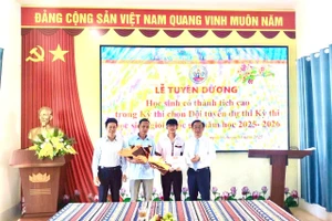 Ban Giám hiệu nhà trường chúc mừng, động viên em Nguyễn Thọ Hoàng Anh, học sinh giỏi môn Địa lí. (Ảnh: ĐTN)