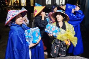 Người dân xã Hòa Thịnh đến UBND xã nhận nhu yếu phẩm sau 3 ngày 2 đêm bám trụ trên các mái nhà. (Ảnh: TT)