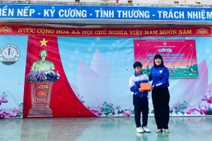 Cô Lê Thị Việt, Hiệu trưởng nhà trường biểu dương, khen thưởng học sinh Hoàng Bảo Lâm. (Ảnh: NT)