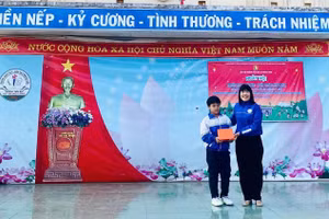Cô Lê Thị Việt, Hiệu trưởng nhà trường biểu dương, khen thưởng học sinh Hoàng Bảo Lâm. (Ảnh: NT)