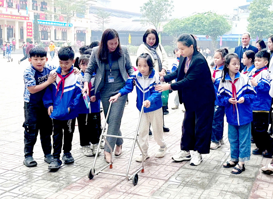 Em Kim Thanh Bình (lớp 3B, Trường Tiểu học Sơn Cẩm 1, phường Quan Triều, tỉnh Thái Nguyên) được hỗ trợ tập đi. 