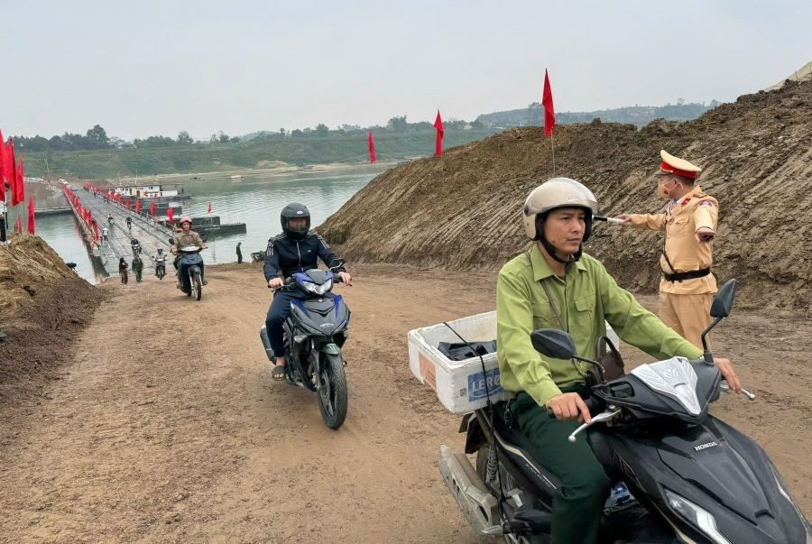 Lực lượng CSGT Công an tỉnh Phú Thọ phân luồng hướng dẫn các phương tiện lưu thông qua cầu phao Đoan Hùng (ảnh CAT Phú Thọ).