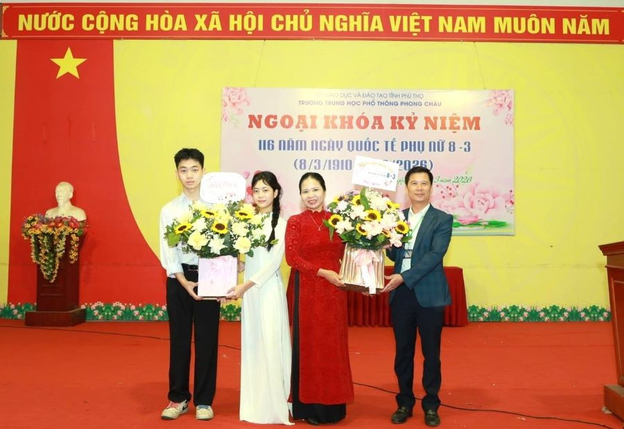 Ông Quách Thành Đô - Hiệu trưởng Trường THPT Phong Châu (thứ nhất bên phải) cùng nam sinh tặng hoa đại diện nữ giáo viên và nữ sinh nhà trường.