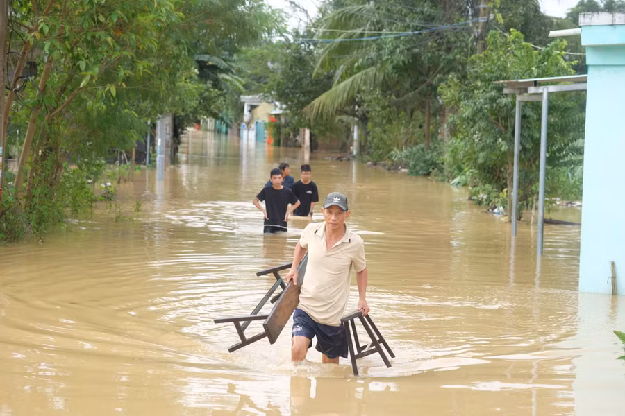 Người dân thôn Gò Hà, xã Hòa Tiến (TP Đà Nẵng) di chuyển đồ đạc trong nước lũ.