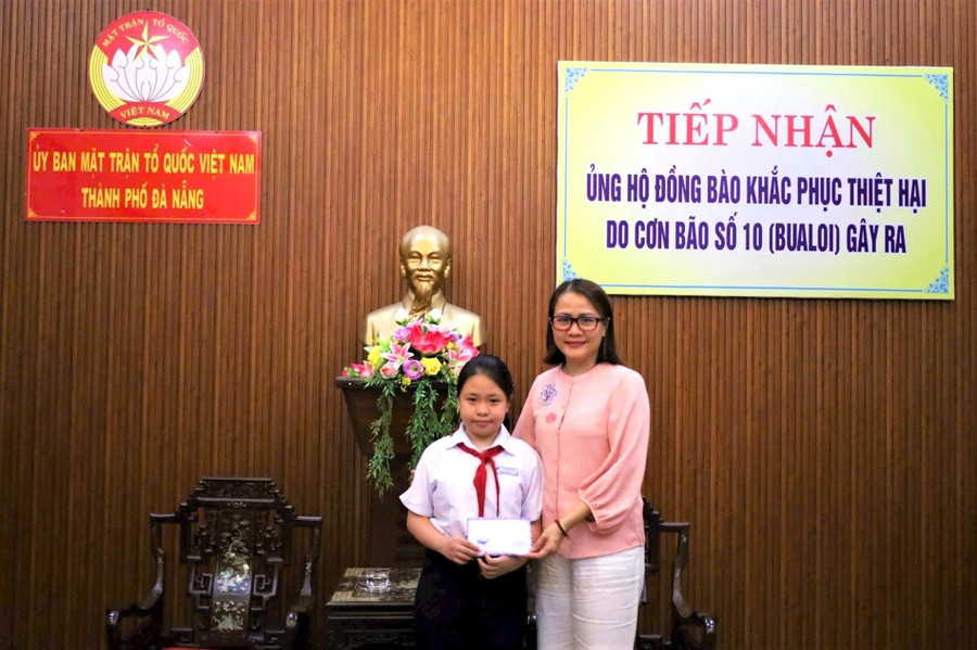 Em Bảo Quyên trao tiền quyên góp ủng hộ đồng bào bị ảnh hưởng của mưa lũ. 