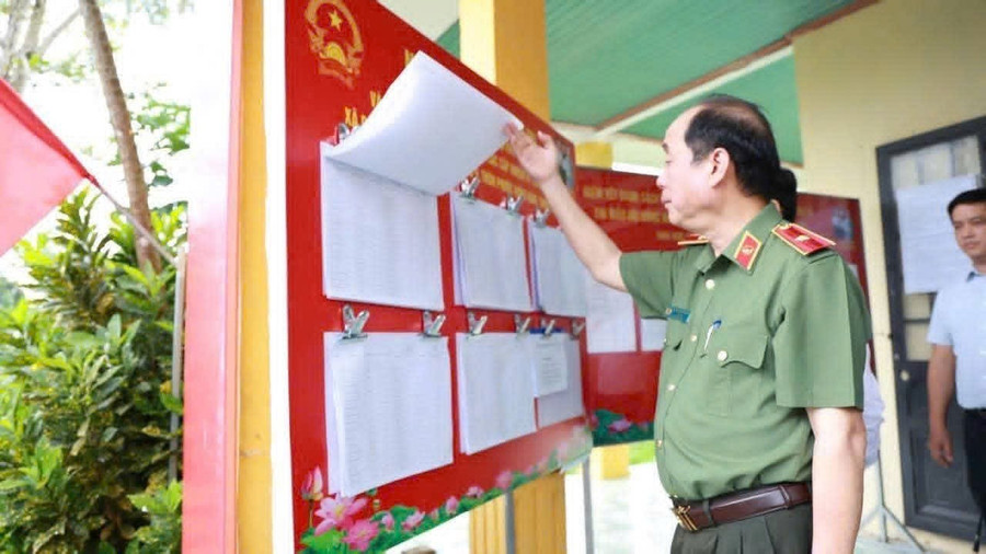 Thiếu tướng Nguyễn Hữu Hợp, Giám đốc Công an TP Đà Nẵng kiểm tra bảng niêm yết danh sách cử tri tại điểm bỏ phiếu bầu cử. Ảnh: CAĐN