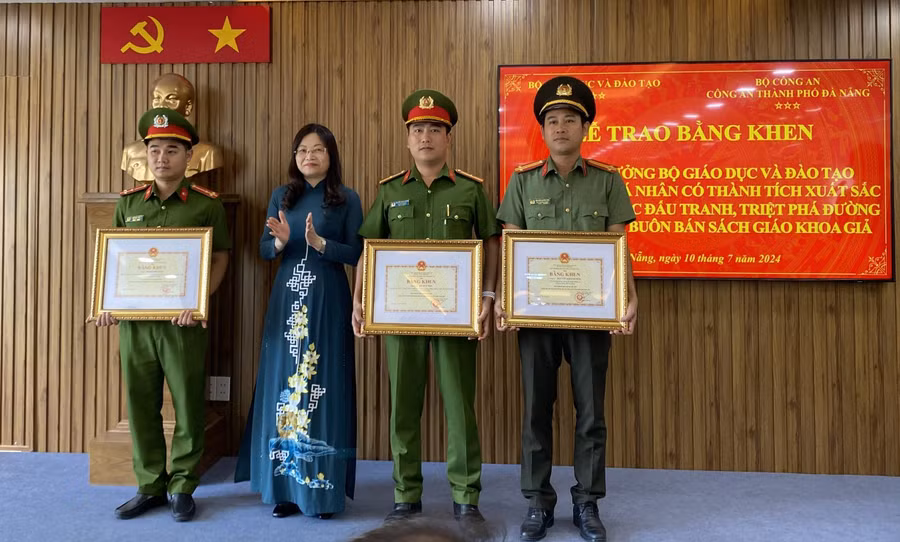 Bà Nguyễn Thị Hạnh – Phó Vụ trưởng Vụ Tổ chức cán bộ (Bộ GD&ĐT) thừa ủy quyền của Bộ trưởng Bộ GD&ĐT trao Bằng khen của Bộ trưởng Bộ GD&ĐT cho 3 cá nhân có thành tích xuất sắc trong việc triệt phá đường dây sản xuất, buôn bán SGK giả.