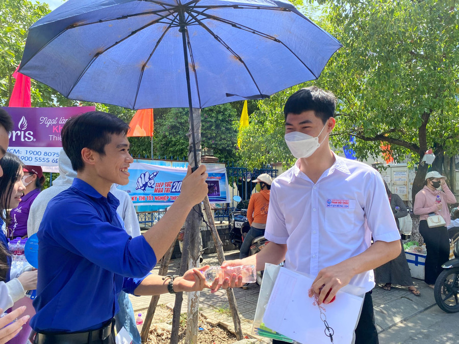 Thanh niên tình nguyện tiếp nước và động viên thí sinh trước giờ thi môn Toán. 7d0dd95d3b838cddd592.jpg